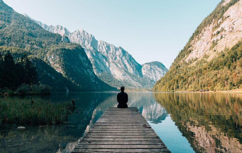 man sitting in front of body of water