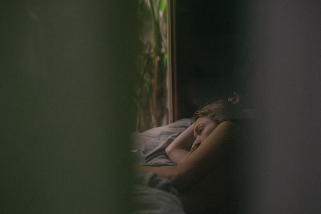 woman lying down on gray bed- Power of Quality Sleep