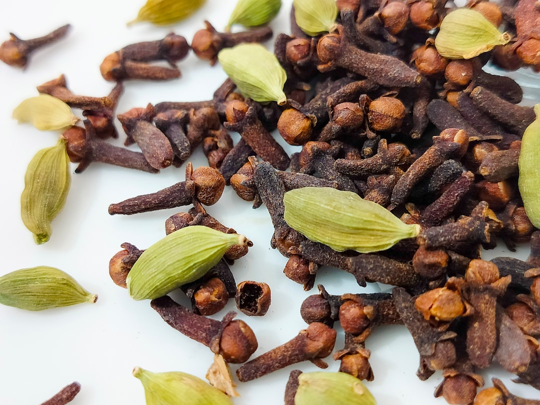 a pile of nuts and seeds on a white surface - Cardamom