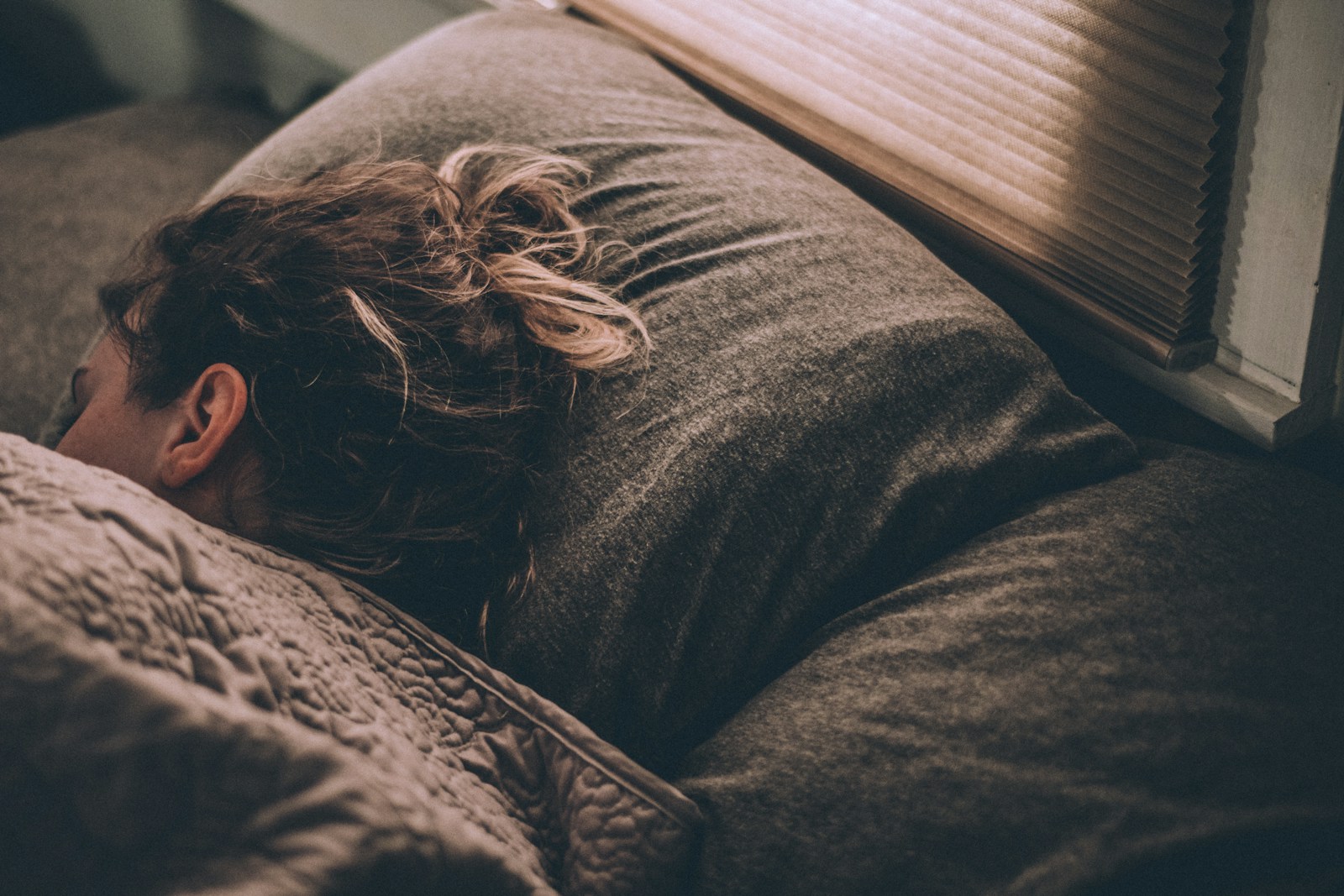 woman sleeping on bed under blankets best sleep of life